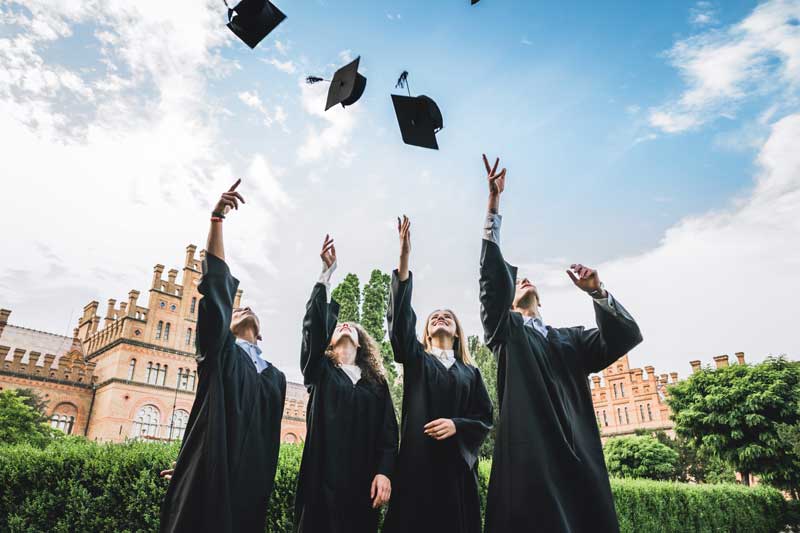 graduating students throwing their grad caps in the air